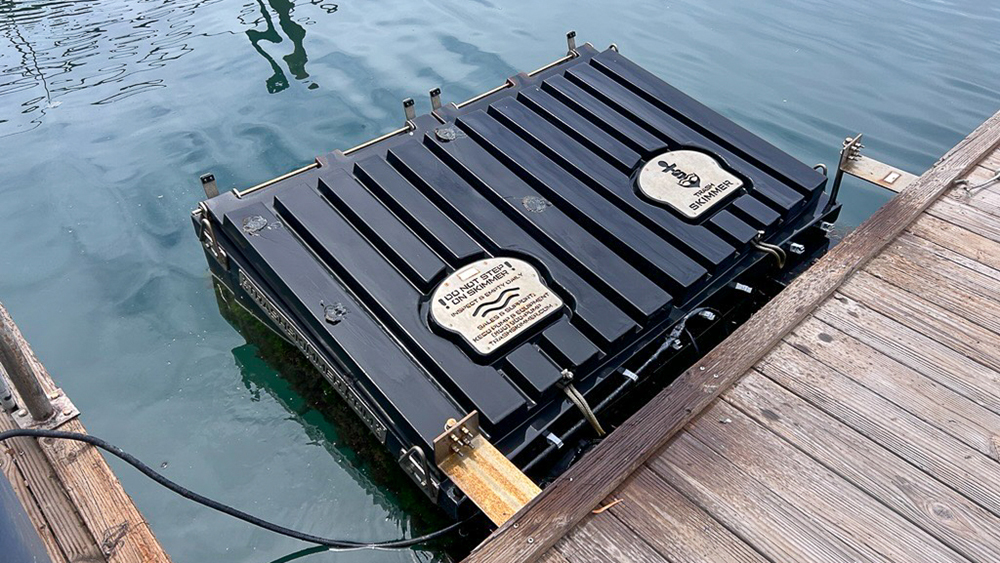 Two debris-collection devices operating in the water near a dock.