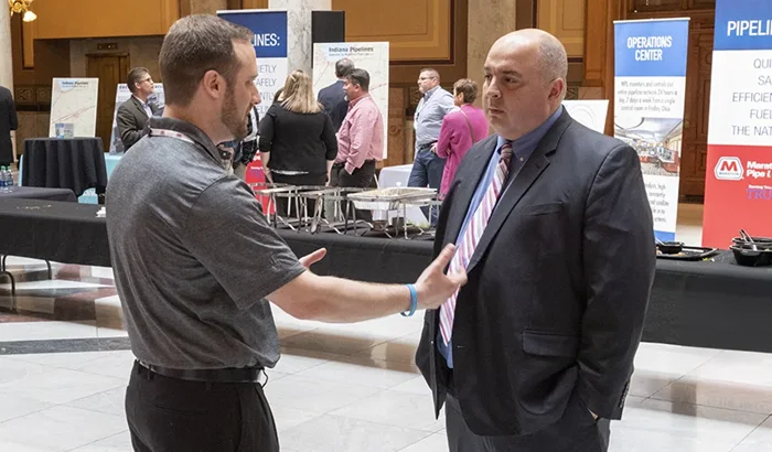 Two men having a discussion in a pipeline educational forum