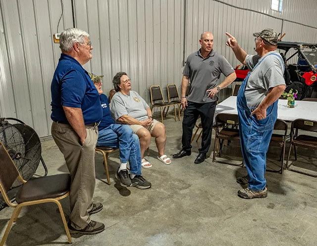 An MPL team leader talking to local farmers outside of a warehouse about pipeline concerns