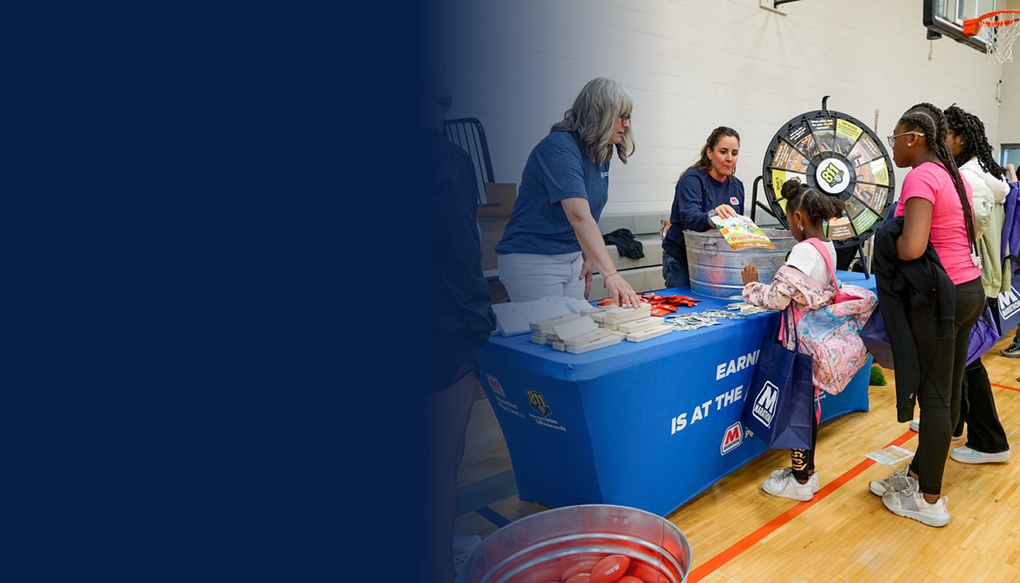 A group of children at an Marathon Pipe Line booth, collecting swag and pipeline safety pamphlets at an event