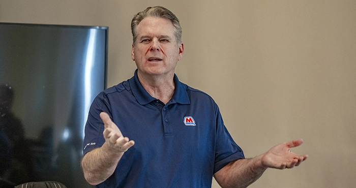 An MPL employee standing in front of a confrence room talking to an audience