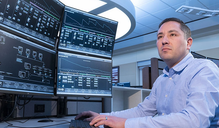 A Marathon Pipe Line operator working at a large data console at an Operation Center